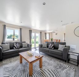 A living room with sofas and a dining area at Raven Lodge Near Brigg