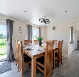 A dining room with a table set for meals at Raven Lodge near Brigg