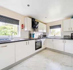 A kitchen with white cabinets and appliances at Charcoal Lodge in Brigg