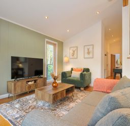 A living room with a television, coffee table, and sofa at 6 Stonerush Valley, Looe