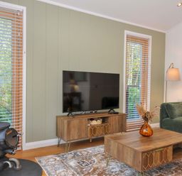 A living room with a wood stove and television at 6 Stonerush Valley in Looe