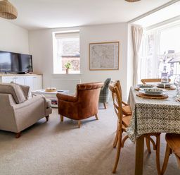 A living room with a television and dining area at The Old Bank Flat North Tawton