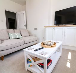 A living room with a sofa and a television at The Old Bank Flat in North Tawton