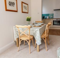 A dining room with a table set for meals at The Old Bank Flat in North Tawton