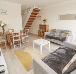 A living room with furniture including sofas and a dining table at Harbour View Poole