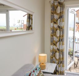A living room with a sliding door and patio furniture at Harbour View Poole