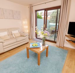 A living room with a sofa and a coffee table at Poole Quay Cottage in Poole