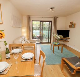 A living room with a sofa and dining area at Poole Quay Cottage in Poole