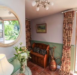 An entryway with a couch and decorative items at Captains Barn in Tiverton