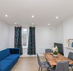 A living room with sofa and dining table at Beachwalk Villa 2 in Whitby