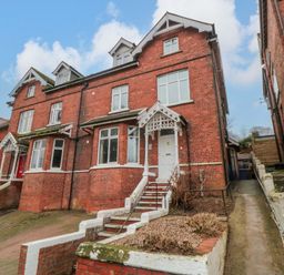 A brick house with stairs and a pathway at Beachwalk Villa 2 in Whitby