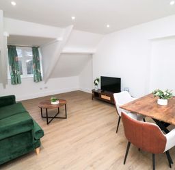 A living room with a sofa and a dining area at Beachwalk Villa 3 in Whitby