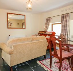 A living room with a sofa and dining table at Camellia Cottage in Bodmin
