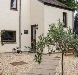 An outdoor area with plants and a sign at Camellia Cottage in Bodmin