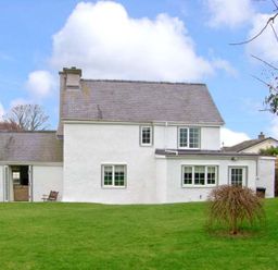 A house with a garden and seating area at Tyddyn Gyrfa Cottage Cemaes Bay