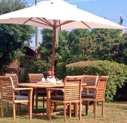 A garden with a table and chairs under an umbrella at Tyddyn Gyrfa Cottage Cemaes Bay