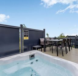 An outdoor area with a hot tub and a dining table at Blencathra Family in Penrith