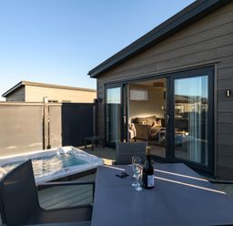 An outdoor area with a hot tub and dining table at Grasmere in Penrith