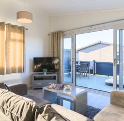 A living room with a television and a sliding door at Grasmere in Penrith