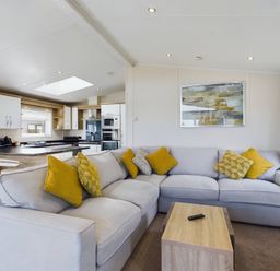 A living room with a sofa and kitchen area at Keswick in Penrith