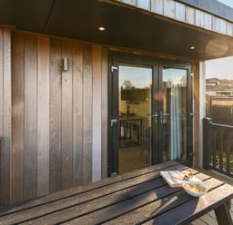 A balcony with a table and snacks at Pods by the Lake in Penrith