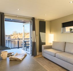 A living room with a sofa and table at Pods by the Lake in Penrith