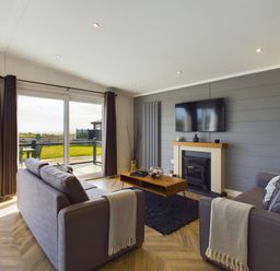 A living room with a sofa and coffee table at Spa Sauna Lodge in Penrith