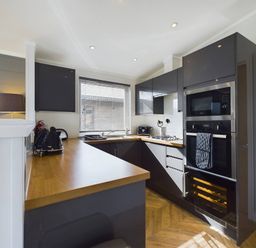 A kitchen with cabinets and appliances at Spa Sauna Lodge in Penrith
