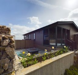 A house with outdoor seating and a fire pit at Spa Sauna Lodge (Pet) Penrith