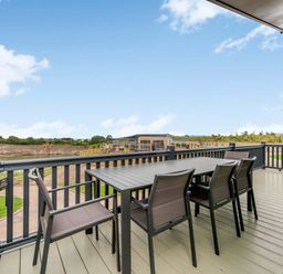 A deck with a table and chairs overlooking a lake at Helvellyn in Penrith