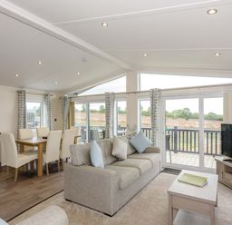 A living room with a sofa and dining area at Helvellyn in Penrith