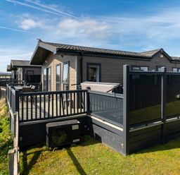 A deck area with a hot tub and seating at Scaféll (Pet) Penrith