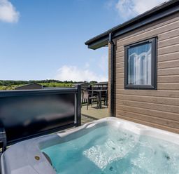 An outdoor area with a hot tub and seating at Scaféll (Pet) in Penrith