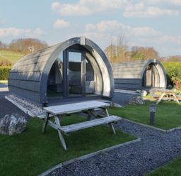 Two camping pods with seating areas at Pod 5 (Pet Friendly) Tewitfield