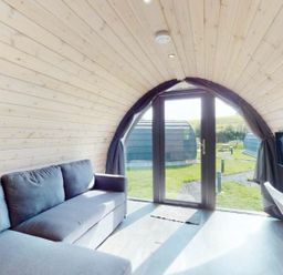 A living area with a sofa and television at Pod 9 (No Pets) in Carnforth