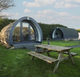 Two camping pods with a picnic table in front at Pod 9 (No Pets) Tewitfield near Carnforth
