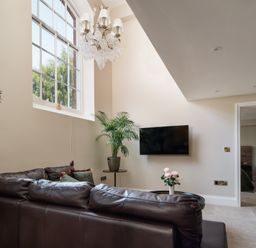 A living room with a television and sofa at The School House in Newton Abbot