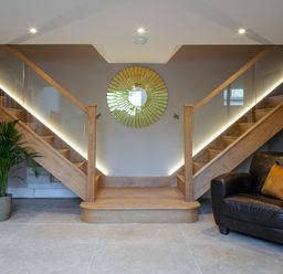 A hallway with stairs and a chair at The School House in Newton Abbot