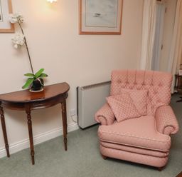 A living room with an armchair and side table at Grange Cottage in Belford