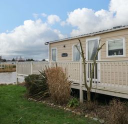 An outdoor area with a mobile home and deck at 62 Guddlebeck in Flookburgh