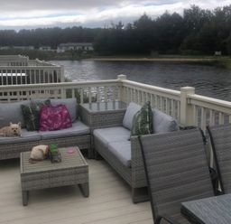 A patio with a sofa, coffee table, and a dog at 62 Guddlebeck, Lakeland Leisure Park, Flookburgh