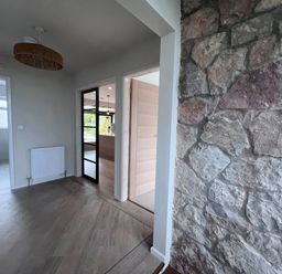 A hallway with a stone wall and doors at 81 Lon Gogarth in Benllech