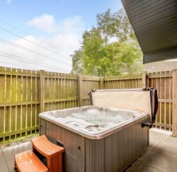 An outdoor area with a hot tub and wooden fence at Muirloch Spa Plus in Dundee