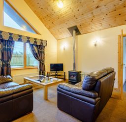 A living room with a sofa and television at Muirloch Spa Plus (Pet) Dundee