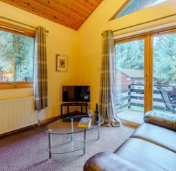 A living room with a tv and a coffee table at Rainbow Lodge in Dundee
