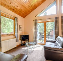 A living room with sofa and television at Barnard Lodge (Pet) Dundee
