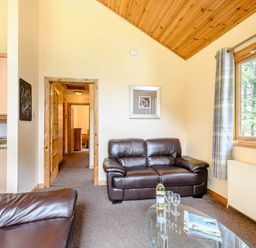 A living room with sofa and glass table at Barnard Lodge (Pet) Dundee