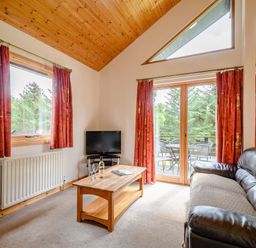A living room with a television and sofa at Osprey Lodge in Dundee