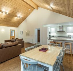 A living room with a sofa and dining table at Galbraith Premier Spa (Pet) Dundee