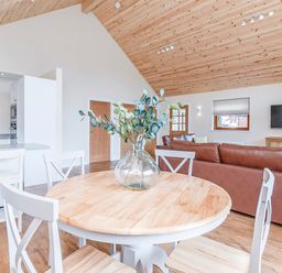 A living room with a table and chairs and couch at Galbraith Premier Spa (Pet) Dundee